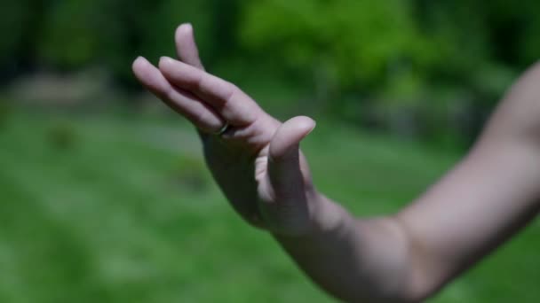 Close - up van een vrouw hand uitvoeren van een yoga asana tijdens meditatie in een park. Kalmeer en ontspan. — Stockvideo