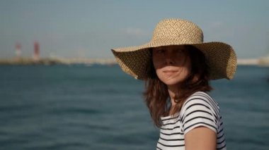 Romantik bir kadın deniz kenarında yürüyor. Sahilde, arka planda güzel bir deniz kestanesinin önünde dinlenen bir kadın. Bronzlaşmış kız seyahati, yaz tatili, temiz hava.