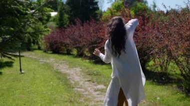 Çiçeklerle tarlada dans eden hippi bir kadın. Doğanın arka planına karşı boho tarzında bir kadın.