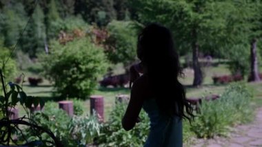 Parkta dans eden hippi bir kadının silueti. Doğanın arka planına karşı gelinlik giymiş bir kadın.