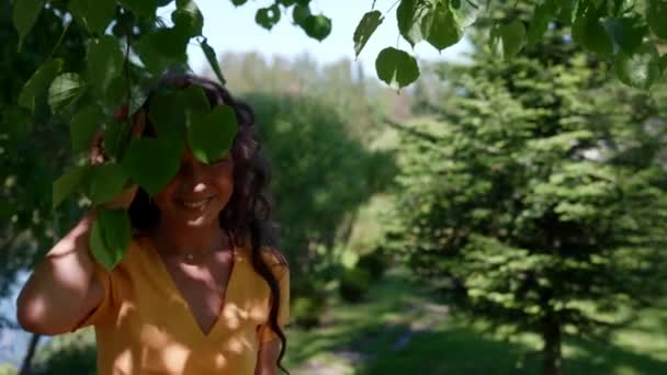 Uma mulher asiática alegre goza de umas férias caminhando por um jardim de verão verde — Vídeo de Stock