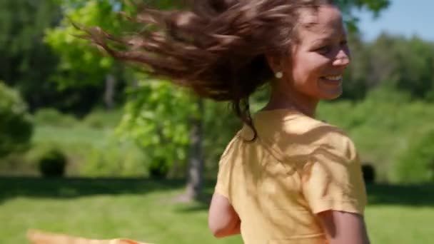 Esbelta mulher bonita feliz em um jardim de verão apreciando a natureza em férias girando em câmera lenta — Vídeo de Stock