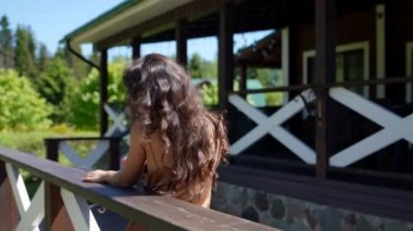 Mutlu, gizemli bir kadın sabahın köründe evin verandasında güneşin tadını çıkarıyor. Parkta yürüyorum. Ülkede tatil.