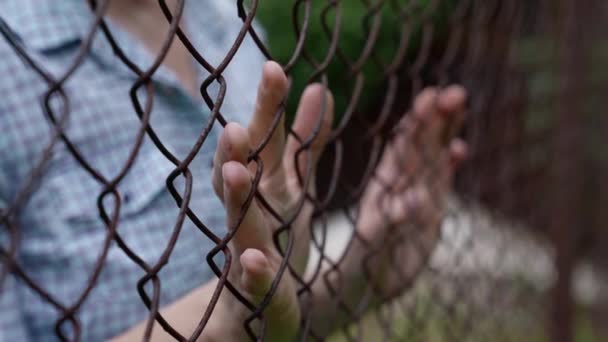 Close-up of a female prisoners hands holding a metal grate — Stock Video