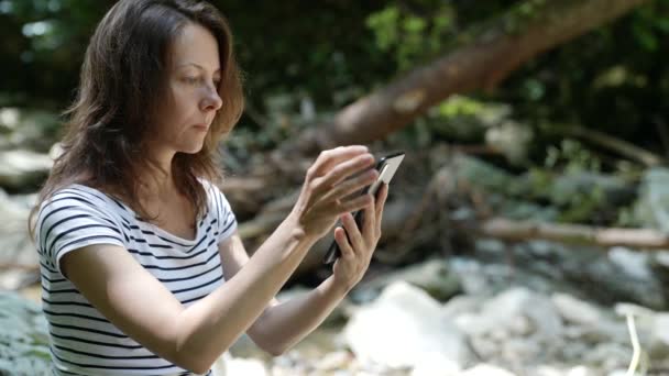 Λεπτή γυναίκα που χρησιμοποιεί ένα smartphone, την αποστολή μηνυμάτων κειμένου σε ένα κινητό τηλέφωνο, τον έλεγχο e-mail επιτυχημένη γυναίκα στις διακοπές — Αρχείο Βίντεο