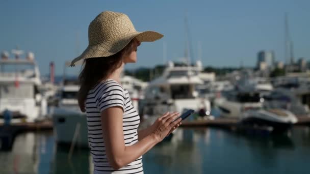 Retrato de una mujer hippie escribiendo en un teléfono móvil al aire libre. Primer plano de una mujer caminando con un teléfono inteligente en un fondo de la ciudad — Vídeos de Stock