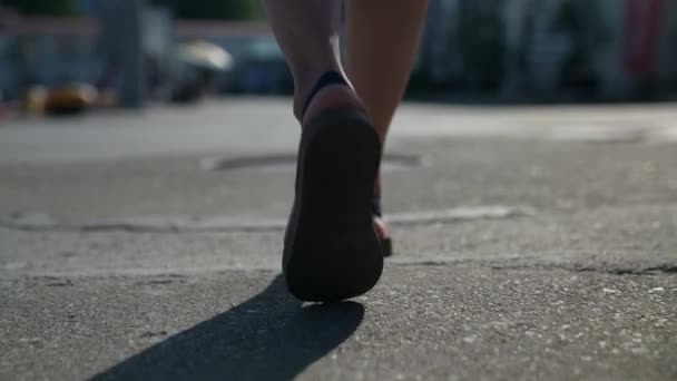 De benen van een toerist, een wandeling langs de straat. het begrip reizen. close-up van een vrouwenbeen. sandalen op de blote voet — Stockvideo