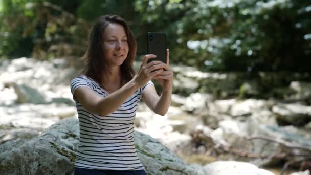 Une femme adulte parle par communication vidéo via un téléphone portable. Une hippie concentrée avec un smartphone. — Video