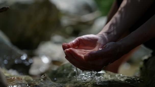 Close-up van het opscheppen van schoon bergwater in uw handen — Stockvideo