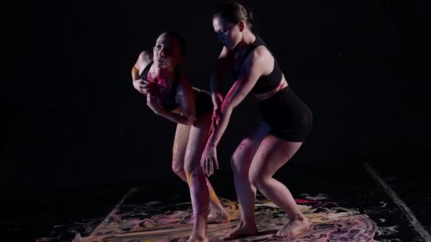 Dos mujeres en ropa interior negra bailan con pinturas en la piel — Vídeo de stock