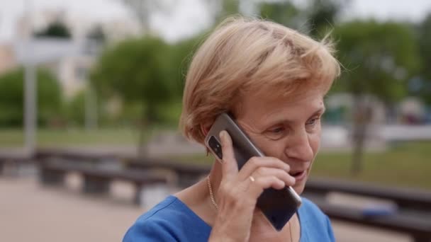 Μια συνταξιούχος μιλάει στο τηλέφωνο στο δρόμο. — Αρχείο Βίντεο