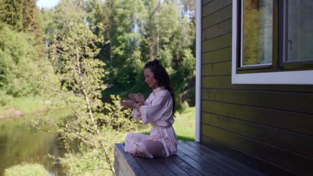 Una mujer practica prácticas respiratorias en la naturaleza por la mañana para restaurar la salud y el equilibrio en la vida — Vídeo de stock
