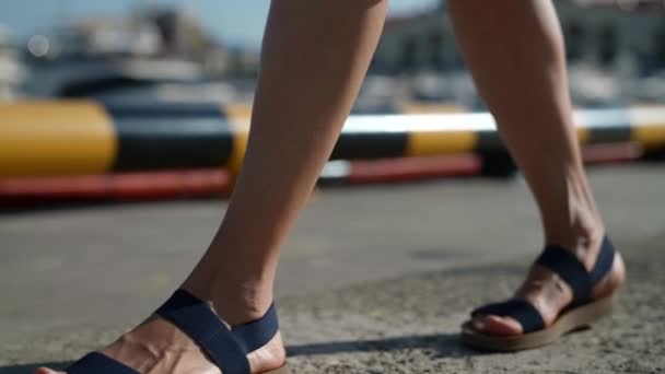 Pieds féminins au ralenti en sandales gros plan marchant sur asphalte — Video