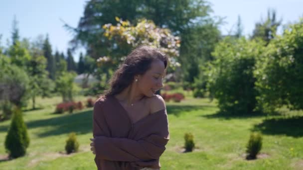 Portrait d'une heureuse femme insouciante souriante lors d'une promenade dans le parc le matin — Video