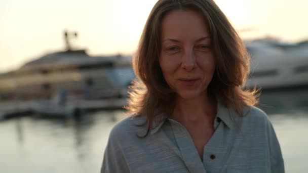 Портрет щасливої дорослої жінки в променях вечірнього заходу сонця — стокове відео