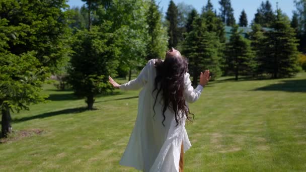Οπίσθια όψη από πίσω ελκυστική νεαρή γυναίκα που χορεύει στο πάρκο αισθάνεται ελεύθερη, αργή κίνηση — Αρχείο Βίντεο