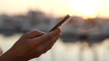 Batan güneşin ışınlarında internete erişmek için telefon kullanma.