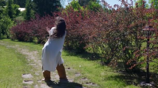 Slender hippie woman dancing in the park view from the back — Stock Video