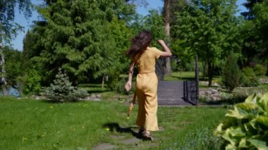 İnce, güzel Asyalı kadın mutlu bir şekilde parkta dolaşır özgürlükten uçar.