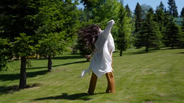 Powolny ruch młody hipis tańczący w długiej tunice w naturze taniec w transie — Wideo stockowe