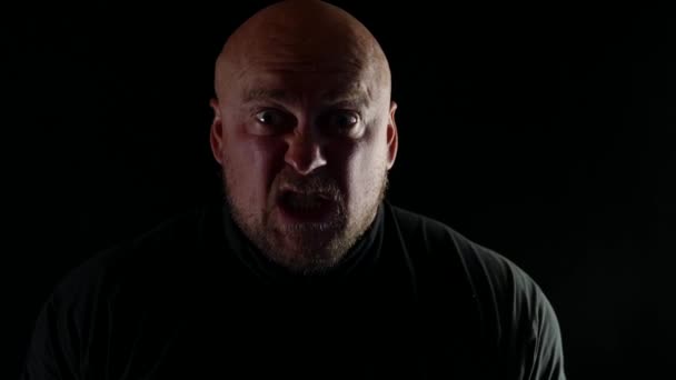 一个怒气冲冲的秃头男人在一个孤立的黑色背景上的特写，从感情痛苦中发出尖叫声 — 图库视频影像