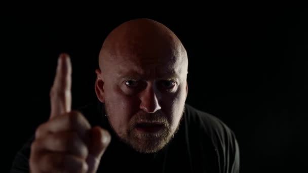 Portrait of an adult bald man a finger gesture forward and threatening speeches an angry look — Stock Video