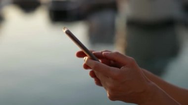 Telefonun dokunmatik ekranında yazı yazan kadınların yakın çekimleri