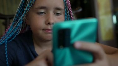 Saçında örgü örgüsü olan güzel bir genç kız gün boyunca bir kafede oturup telefonuna bir mesaj yazıyor.
