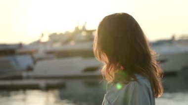 Güzel, doğal bir kadının portresi. Tatildeki bir tatil köyünde akşam güneşinin tadını çıkarıyor.