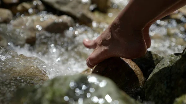 Detailní záběr ženské nohy ponořující se do živé přírodní horské vody pro příjem energie země Stock Snímky