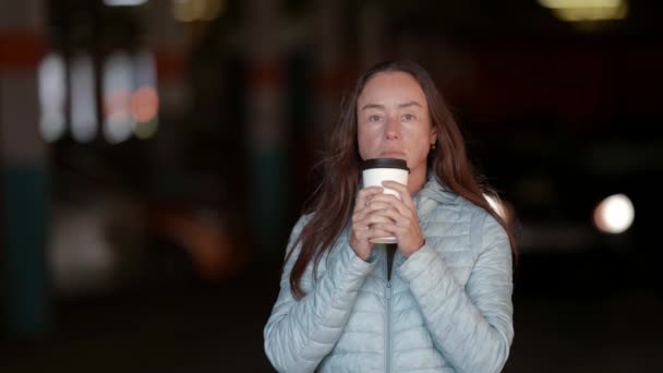 Портрет вдумчивой женщины на парковке с бумажной чашкой кофе, стоящей и думающей: — стоковое видео