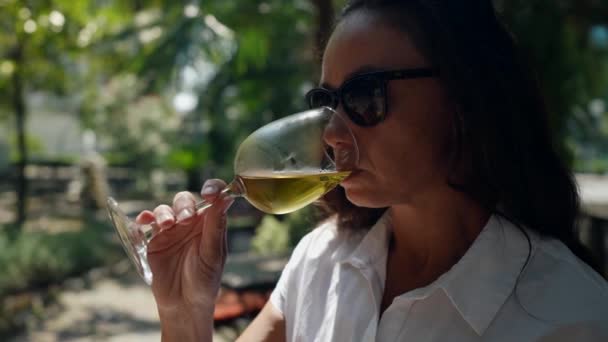 休暇中の午後にレストランのベランダで冷たい白ワインを飲む女性のクローズアップ肖像画 — ストック動画