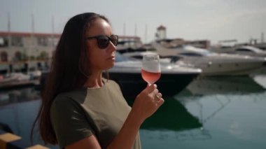 Başarılı bir yetişkin kadın tatilini sahilde pembe bir şampanyayla kutlar.