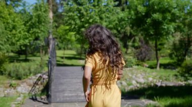 İnce, çekici Asyalı kadın güneşli bir yaz gününde parkta yürüyüş yapıyor.