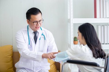 Doktor tedavisi. Hastanedeki tekerlekli sandalyede oturan kadının kol ağrısı. Sağlık sigortası konsepti..