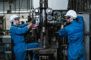 Üniformalı güvenlik işçileri giyen mühendis fabrikada tamirat yapıyor metal torna, endüstri işçisi konsepti.