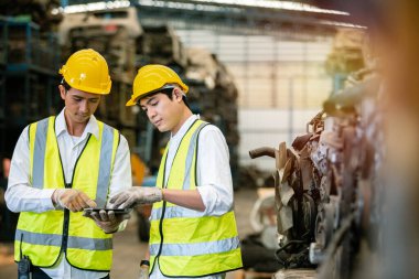 Ekip mühendisleri, işçiler üniforma ve kask muhabbeti giyer ve depoda çalışmak için tablet kullanır. İşyeri fabrikası endüstriyel ağır makine. resim pankartı boyutu.