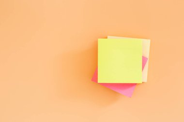 Turuncu arkaplandaki yapışkan not kağıdını istifle. Kağıt not gönder..