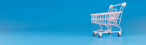 Ροζ Παστέλ Καλάθι Αγορών Μπλε Φόντο Τρόλεϊ Στο Σούπερ Μάρκετ — Φωτογραφία Αρχείου
