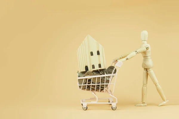 Wooden Mannequin Puppet Pushing Shopping Cart Wooden House Coins Money — Stock Photo, Image