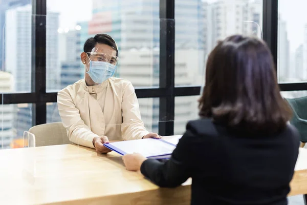 顔のマスクと顔のシールドを身に着けているアジアのオフィスの労働者は 企業のオフィスに存在する文書を保護します 報告書のコンセプト — ストック写真