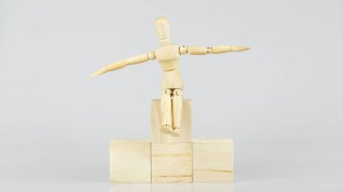 Tahta manken podyumda oturuyor. Kazanan beyaz arka planda, hedef hedef hedef. Resim boyutu 16-9.