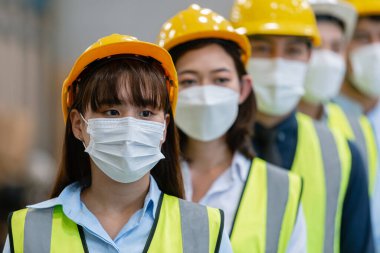 Üniformalı takım çalışması, atölye endüstriyel fabrikasında şapka ve koruma maskesi takar. işçi profesyonel imalat.