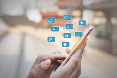 Uyarı sosyal medya simgeleri, internet dijital pazarlama kavramına sahip akıllı telefon ekranını parmakla göstermek.