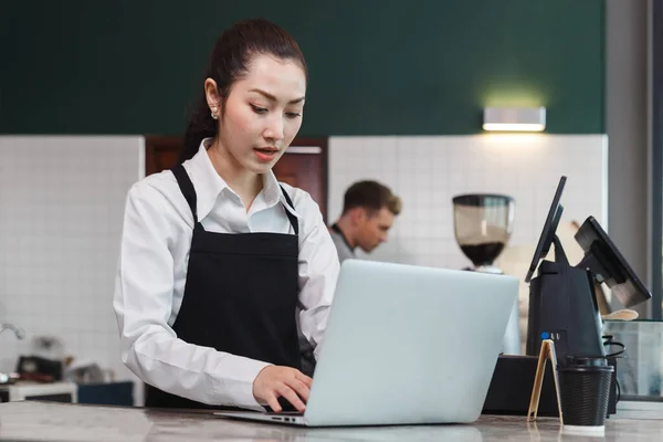 Asiático Jovens Mulheres Barista Desgaste Avental Usando Laptop Café Equipe — Fotografia de Stock