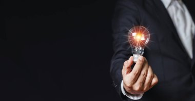 Elinde ampul tutan bir iş adamı. yaratıcı yenilik. güç vizyonu ve fikirler kavramı.