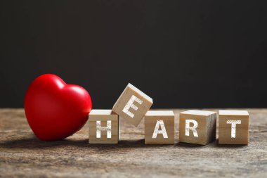 Kırmızı kalp, tahta blok küp, alfabe yazısıyla ahşap masada Heart. Aşk ve sağlık kavramı. 