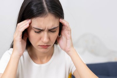 Şakaklarına acı ifadesiyle dokunan, baş ağrısı ya da migren belirtileri gösteren kadınların kapatılması, sağlık, stres, ağrı kesici veya tıbbi durum içeriği için mükemmel.