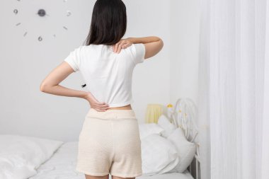 Yatak odasında elleri belinin üstünde ve altında duran kadınlar sırt ağrısı ya da kas zorlanması belirtileri gösteriyorlar. Kötü duruş, sakatlık veya omurilik geriliminden kaynaklanan sağlık sorunları.