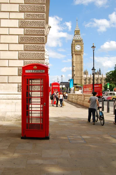 在炎热的夏天在伦敦大笨钟旁边红色电话亭 免版税图库照片
